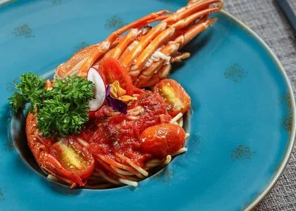 Plate of chili prawns with herbs on a blue ceramic dish